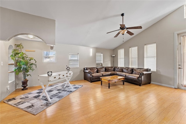 living room featuring a ceiling fan, arched walkways, high vaulted ceiling, and light wood finished floors