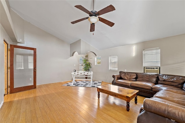 living area with lofted ceiling, cooling unit, ceiling fan, and light wood-style flooring