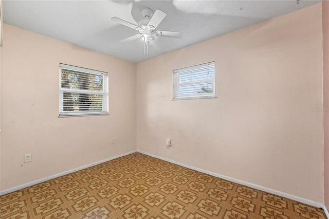 unfurnished room featuring light floors, a wealth of natural light, baseboards, and a ceiling fan