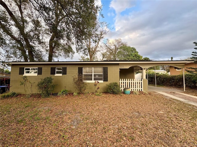 5607 Huber Dr, Orlando, FL 32818 - view of front of home with an attached carport, concrete block siding, fence, and concrete driveway