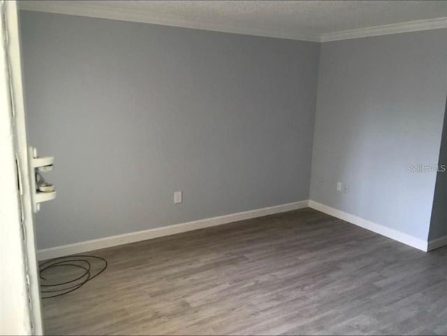 empty room with ornamental molding and hardwood / wood-style flooring