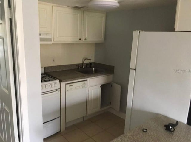 kitchen featuring white appliances, light tile patterned floors, white cabinets, backsplash, and sink