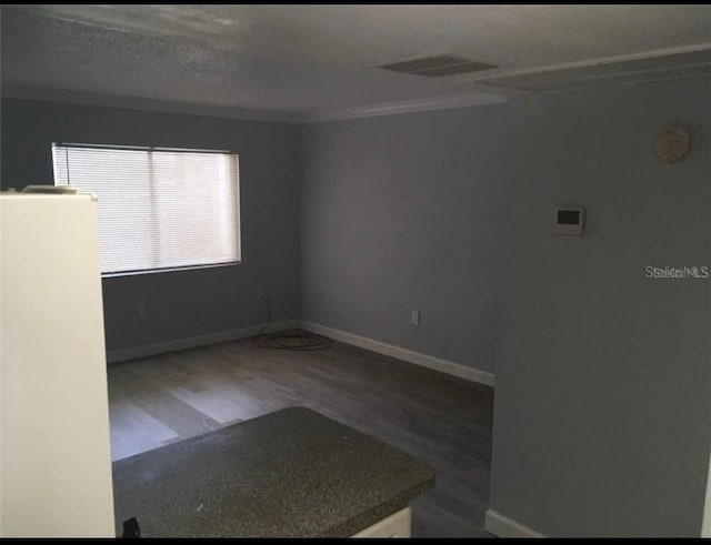 empty room featuring a textured ceiling and hardwood / wood-style floors