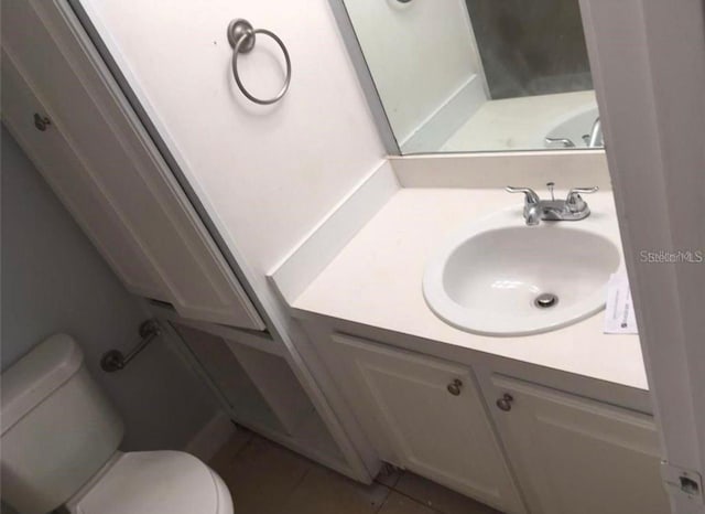 bathroom featuring tile patterned floors, vanity, and toilet