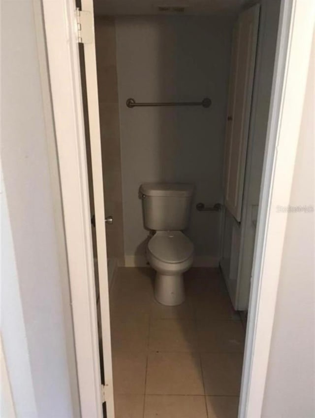 bathroom with toilet and tile patterned floors