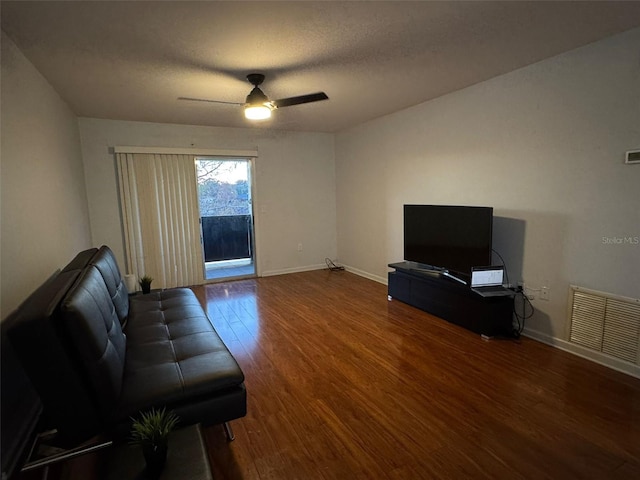 living room featuring ceiling fan, a textured ceiling, and hardwood / wood-style flooring