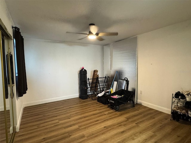 workout room featuring a textured ceiling, ceiling fan, and dark hardwood / wood-style floors