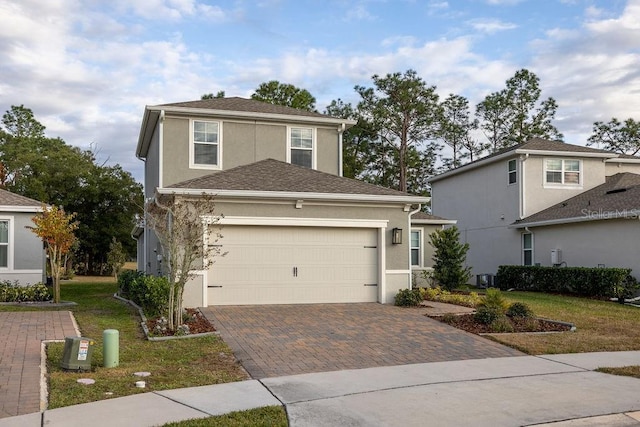 view of front property featuring a front lawn and a garage