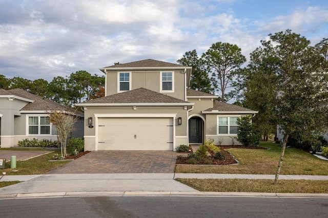 front facade featuring a front lawn and a garage