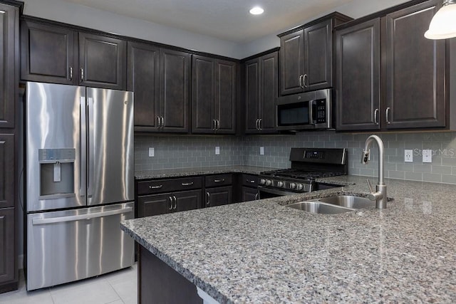 kitchen featuring light tile patterned flooring, appliances with stainless steel finishes, backsplash, and sink