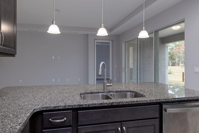 kitchen featuring light stone countertops, dark brown cabinetry, sink, hanging light fixtures, and stainless steel dishwasher