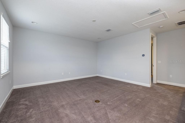 unfurnished room featuring dark carpet