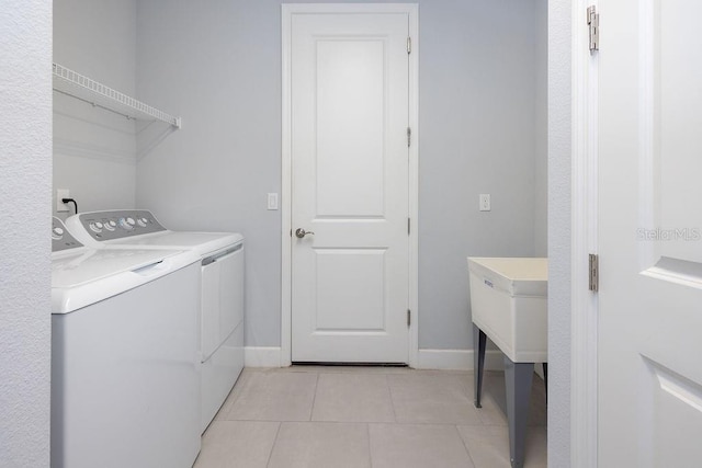 laundry room with washer and clothes dryer and light tile patterned flooring