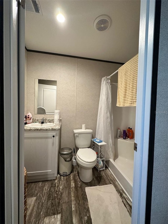 bathroom with toilet, vanity, curtained shower, and hardwood / wood-style floors