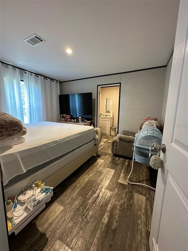 bedroom featuring dark hardwood / wood-style floors and connected bathroom