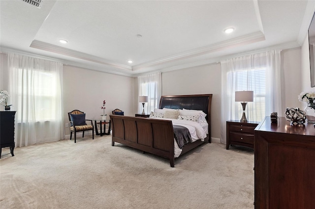 bedroom with ornamental molding, a tray ceiling, visible vents, and light colored carpet