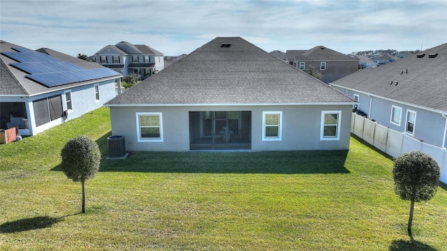 back of property featuring a shingled roof, a lawn, fence, central air condition unit, and stucco siding