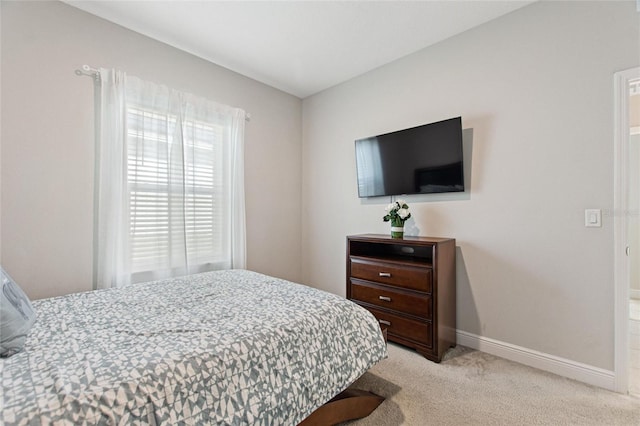 bedroom featuring baseboards and light colored carpet