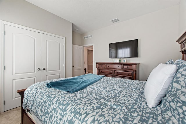 bedroom with light carpet, a closet, a textured ceiling, and visible vents