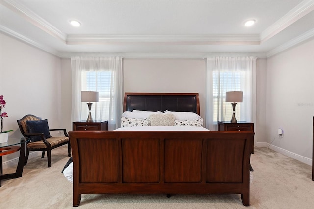 bedroom with a tray ceiling, light carpet, and multiple windows