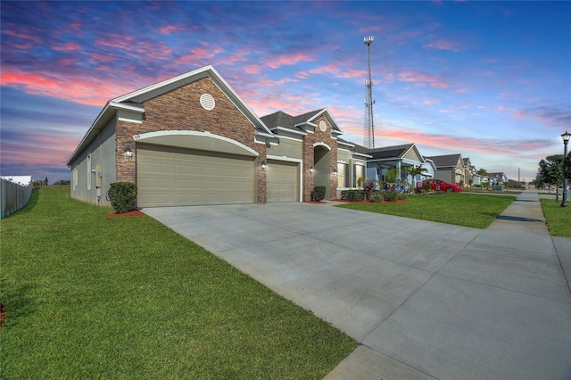 view of front of home featuring a garage, stone siding, concrete driveway, and a front yard