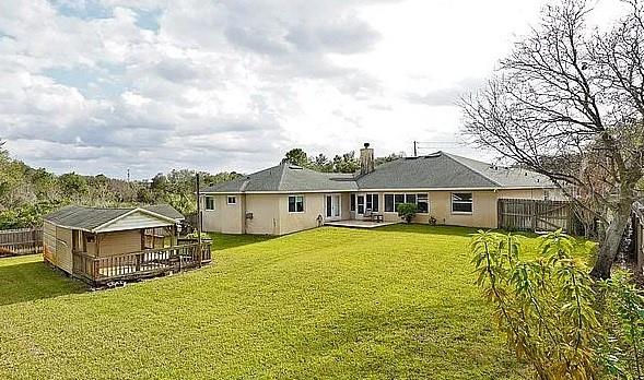 back of house with a yard, fence, and a chimney