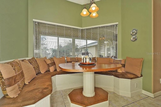 dining area with an inviting chandelier, tile patterned floors, a high ceiling, and breakfast area