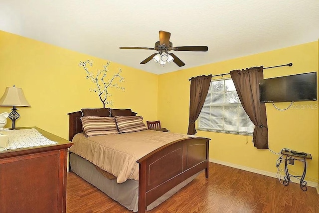 bedroom featuring a ceiling fan, baseboards, and dark wood-style flooring