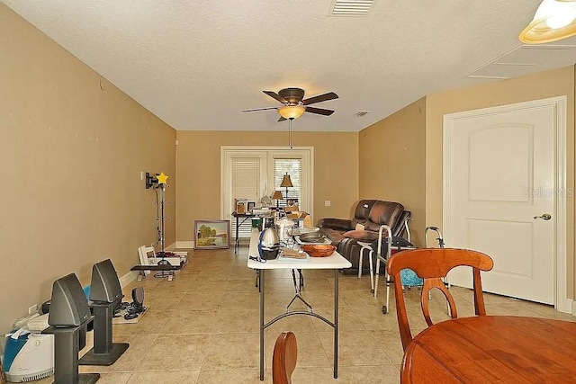 dining space featuring light tile patterned flooring, visible vents, a textured ceiling, and a ceiling fan