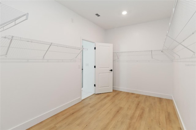 walk in closet with hardwood / wood-style floors