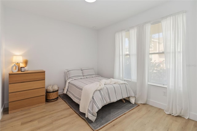 bedroom featuring multiple windows and light wood-type flooring