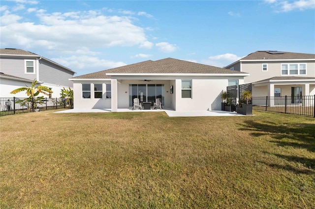 rear view of property featuring ceiling fan, a lawn, and a patio