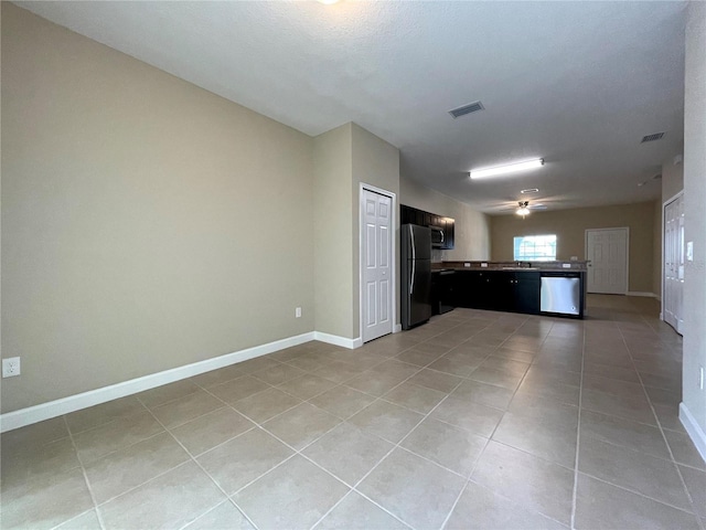 kitchen featuring ceiling fan, light tile patterned flooring, stainless steel appliances, and a textured ceiling