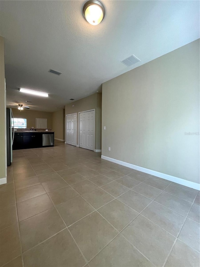 unfurnished living room featuring a textured ceiling, tile patterned floors, and sink