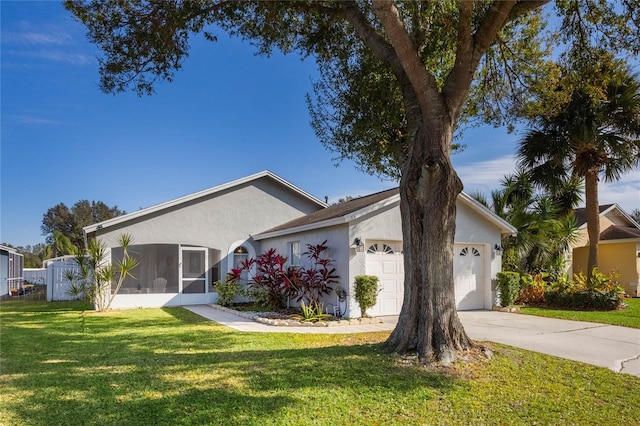 ranch-style house with a sunroom, a front lawn, and a garage