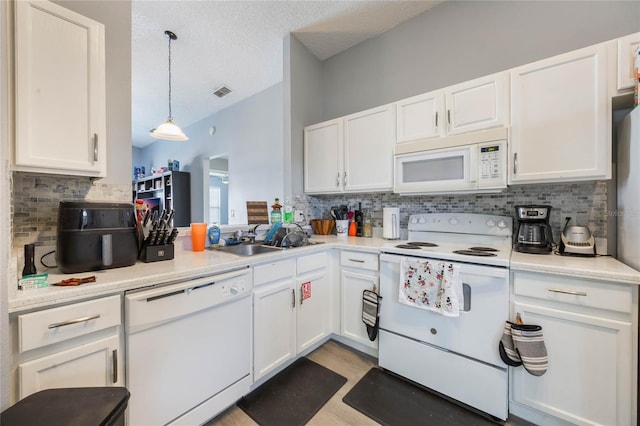 kitchen with decorative backsplash, white appliances, hanging light fixtures, white cabinets, and sink