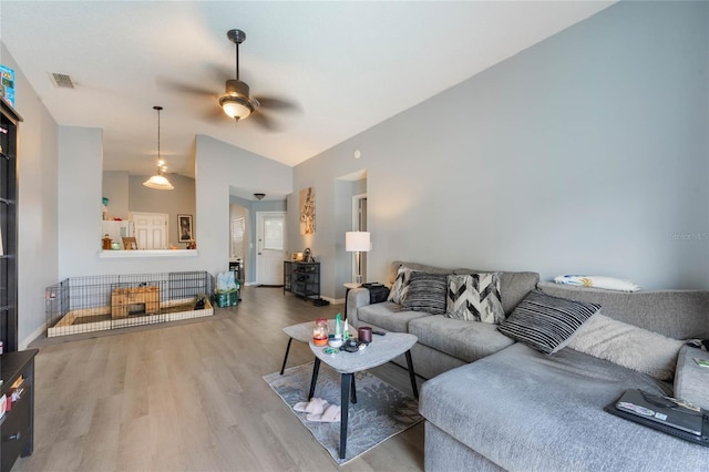 living room featuring ceiling fan, wood-type flooring, and lofted ceiling