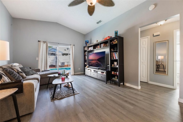 living room featuring ceiling fan, vaulted ceiling, and wood-type flooring