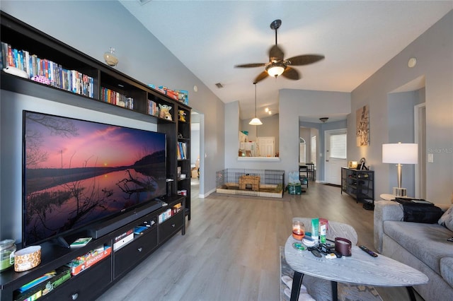 living room with ceiling fan, lofted ceiling, and light wood-type flooring