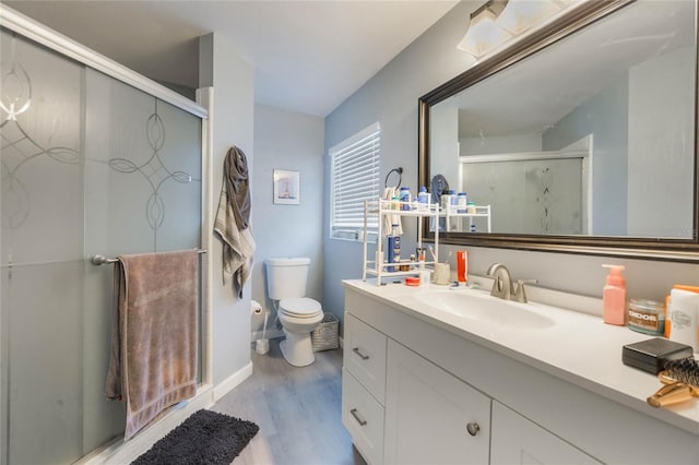 bathroom featuring toilet, vanity, wood-type flooring, and a shower with door