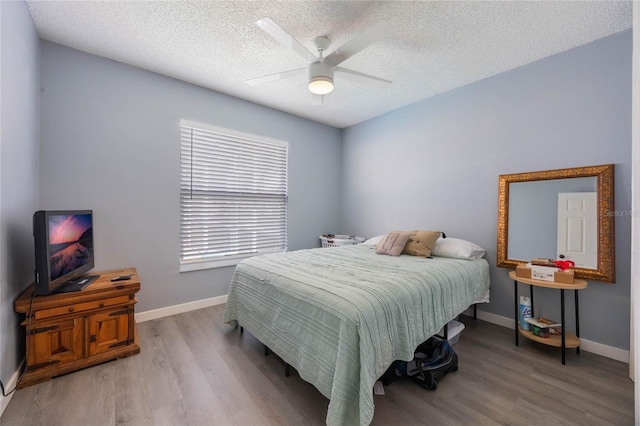 bedroom featuring a textured ceiling, ceiling fan, and wood-type flooring