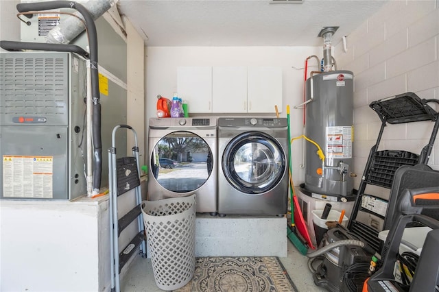 clothes washing area featuring heating unit, water heater, and washing machine and dryer