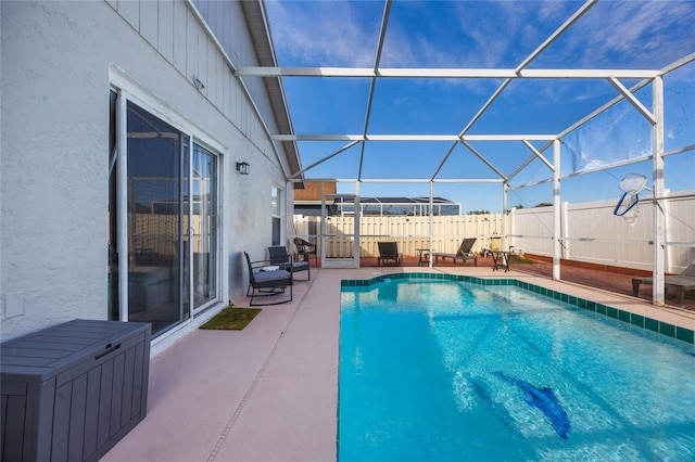 view of pool featuring glass enclosure and a patio