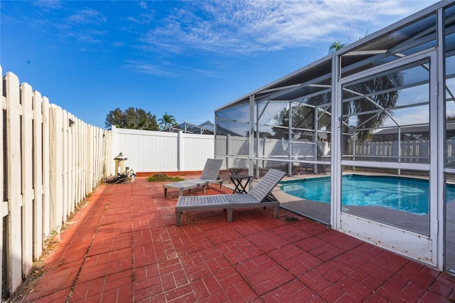 view of patio featuring glass enclosure and a fenced in pool