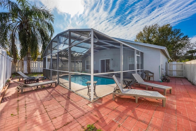 view of swimming pool featuring glass enclosure and a patio area