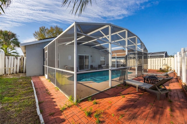 view of swimming pool with glass enclosure and a patio area