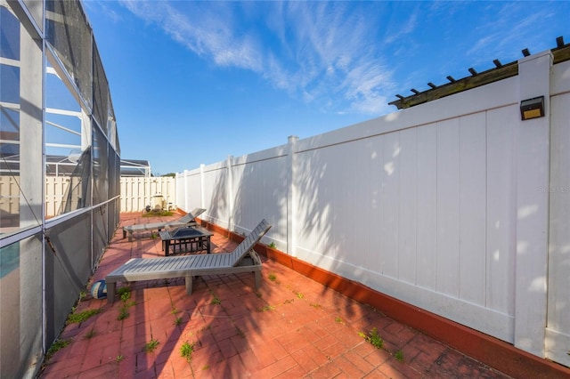 view of patio featuring glass enclosure