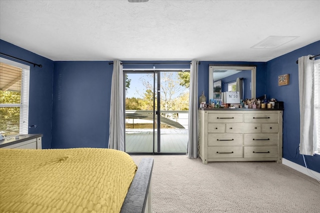 bedroom with access to exterior, light colored carpet, a textured ceiling, and baseboards