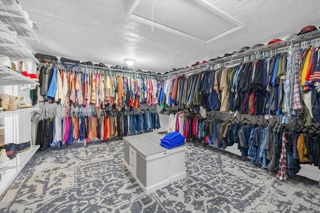 walk in closet featuring carpet and attic access