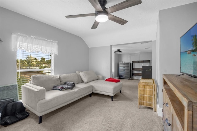 living area featuring light carpet, vaulted ceiling, and a ceiling fan